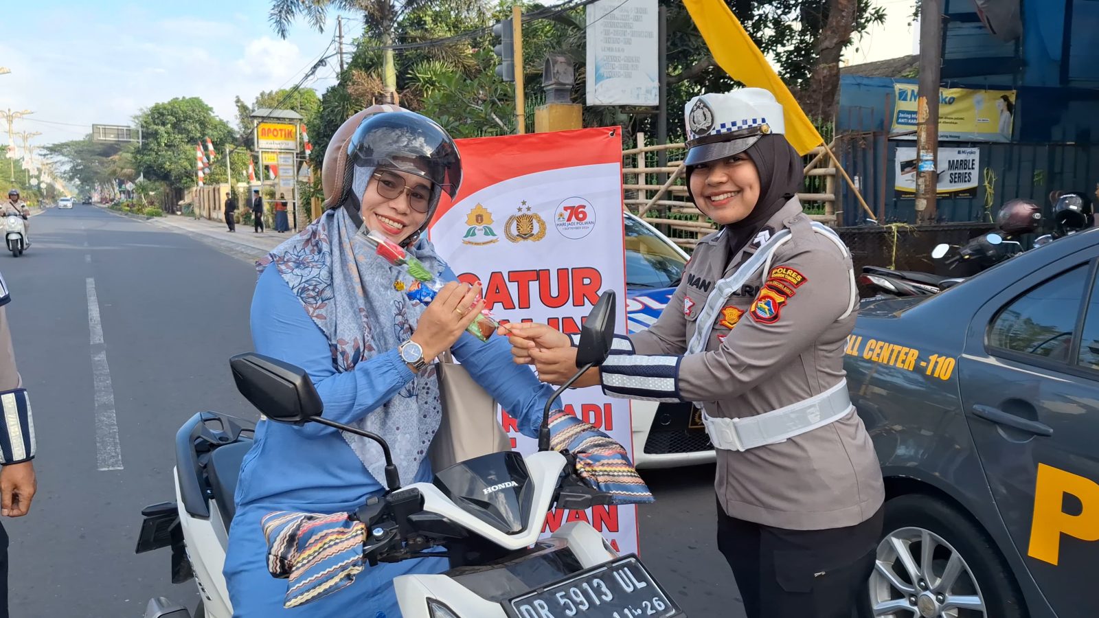 Polwan Polres Loteng Bagikan Bunga dan Coklat Kepada Pengendara.