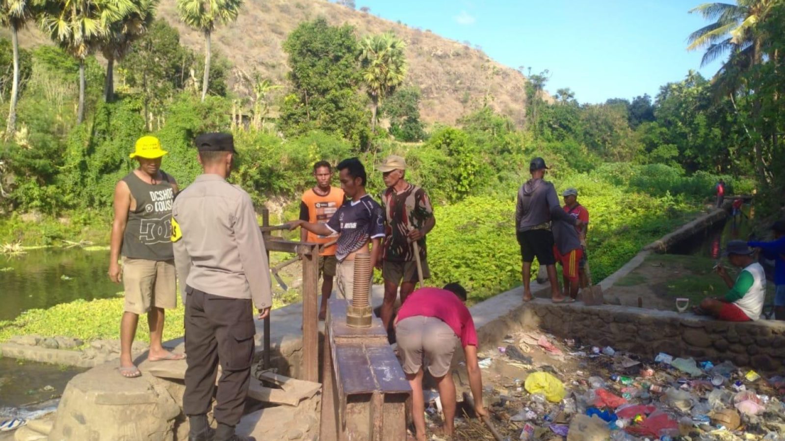 Bhabinkamtibmas Desa Nipa Gotong Royong Bersihkan Saluran Irigasi Bersama Warga
