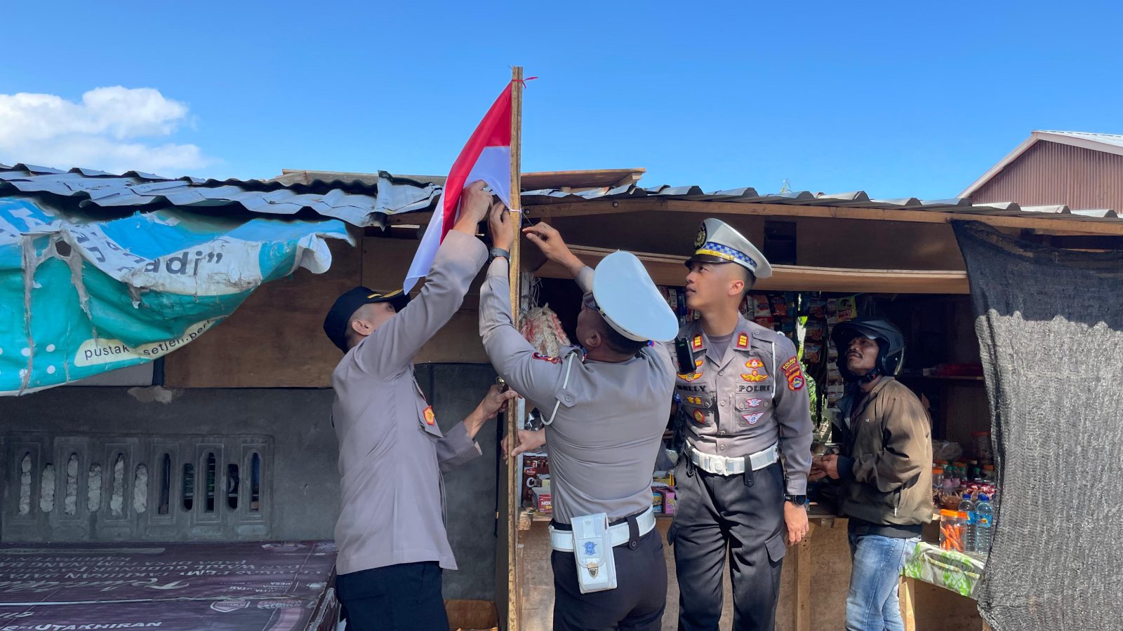 Polres Lombok Utara Bagikan Bendera Merah Putih di Jalan Raya